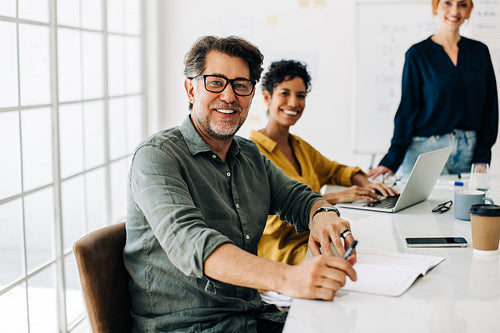 Mature business professional sitting in a boardroom meeting at work