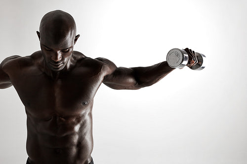 Muscular african fitness model working out with dumbbells