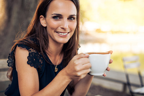 Smiling young woman with a cup of coffee