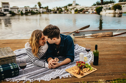 Couple in love on a date sitting beside a lake