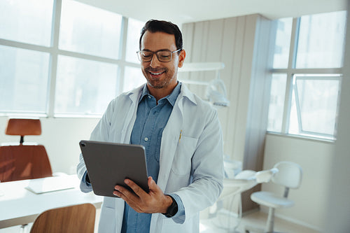 Dentist using tablet in modern clinic for patient care