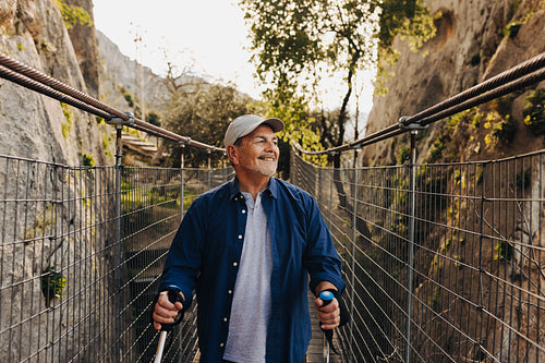 Senior man trekking with hiking poles outdoors