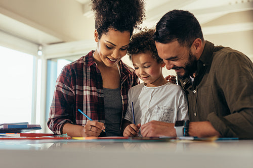Man and woman helping child in writing