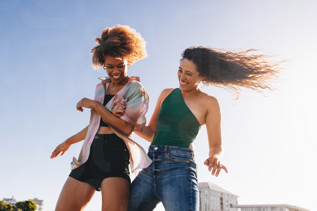 Energetic Friend Energetic young friends dancing and laughing outdoors β Jacob Lund ...