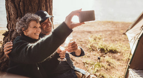 Senior couple taking a selfie at the lake