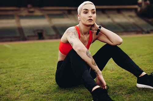 Woman in fitness clothes relaxing sitting inside a stadium