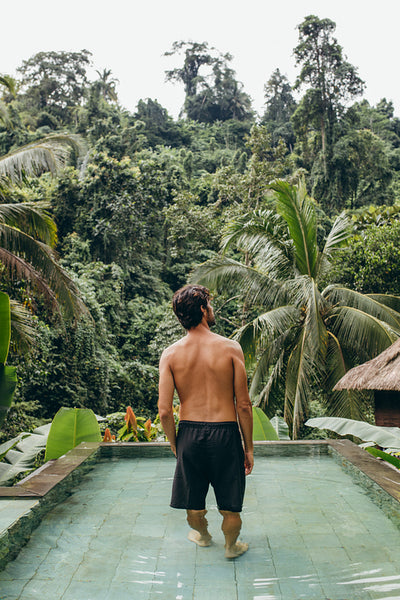 Young man standing in pool and looking away
