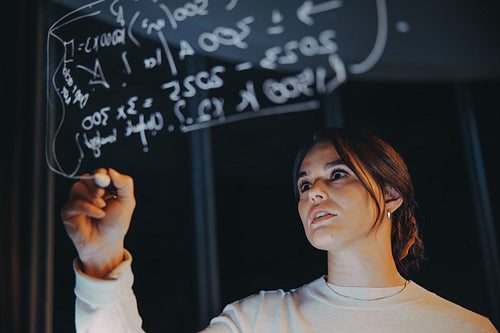 Businesswoman engaging in creative brainstorming and data analysis at night