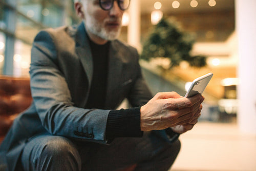 Businessman using smart phone in office lounge