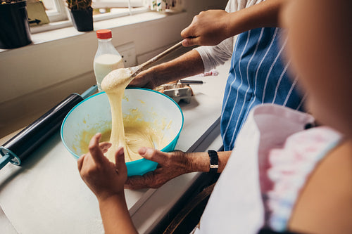 Two women making batter for cake