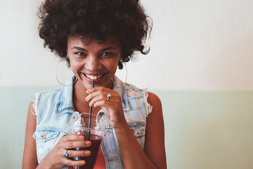Young african woman enjoying a fresh fruit juice