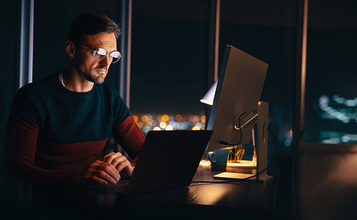 Virtual meeting at night: Businessman connecting with his colleagues while working from home