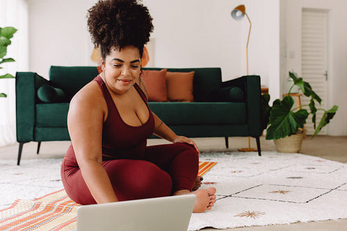 Healthy woman exercising using laptop at home
