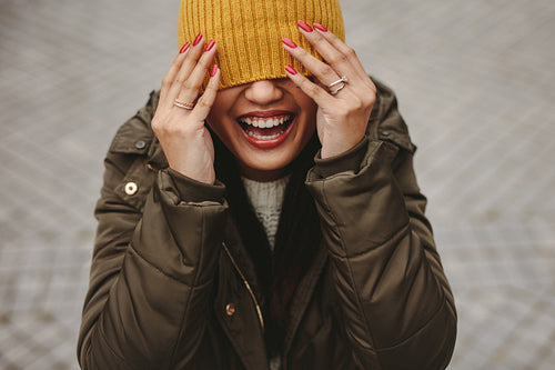 Close up of a smiling woman with partially covered face