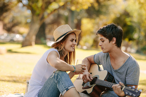 Couple on picnic sitting in a park having fun