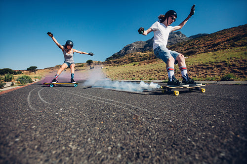 Young people longboarding down the road