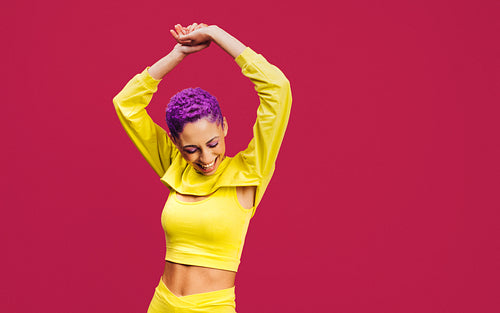 Woman with purple hair dancing in the studio