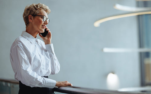 Mature business woman using a mobile phone to make a phone call to her partners