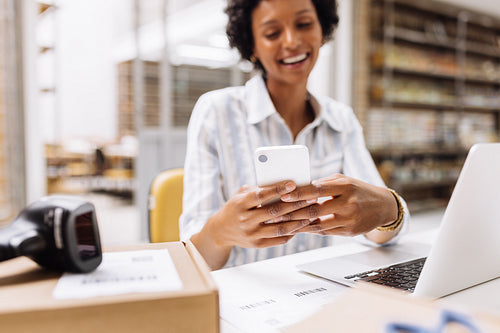 Successful online store manager reading a text message on her smartphone