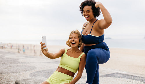 Fit women taking a selfie together, celebrating their fitness achievements