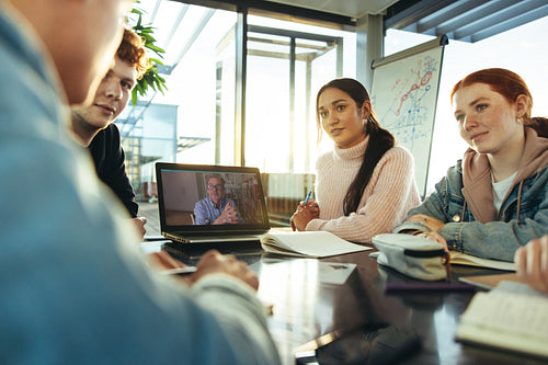 Students having video call meeting with professor in college