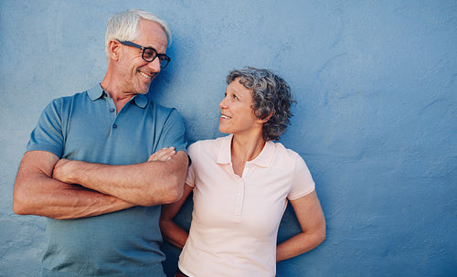 Portrait of affectionate mature couple against a blue wall