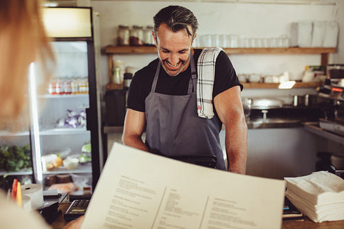 Cafe owner taking order from customer