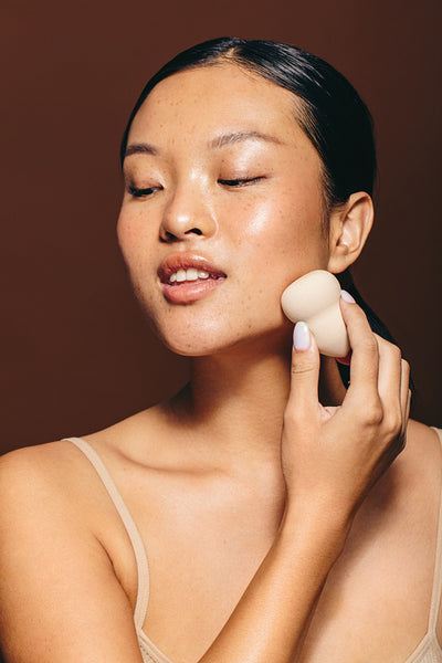Skincare with a beauty sponge: Woman applies facial treatment with a blender