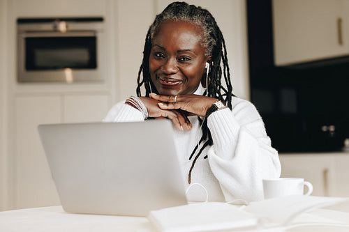 Cheerful senior businesswoman working in her home office