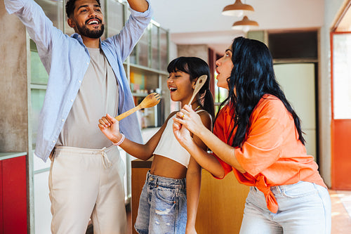 Happy family singing and bonding together in the kitchen at home
