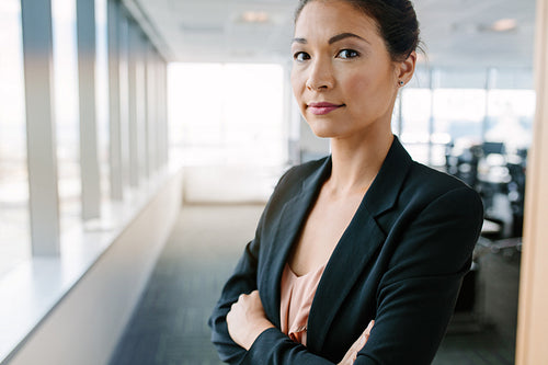 Mature businesswoman in office with her arms crossed