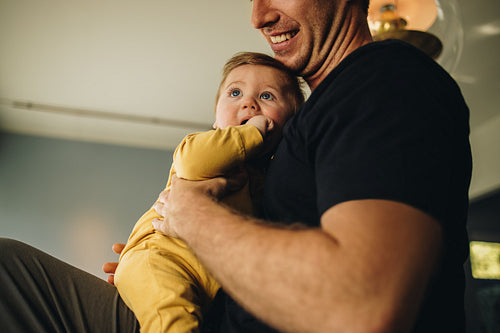 Father sitting with his baby at home