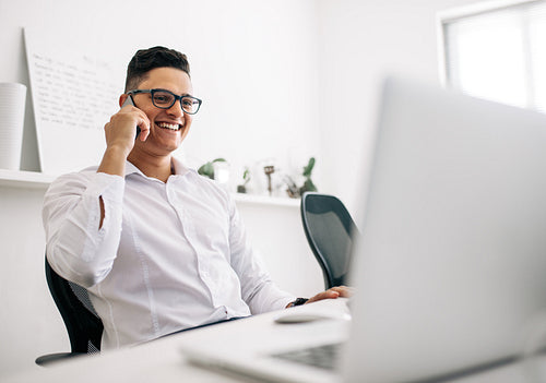 Man talking on mobile phone in office