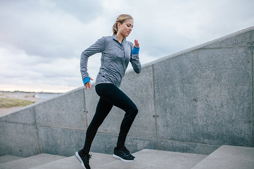 Young woman running alone up stairs