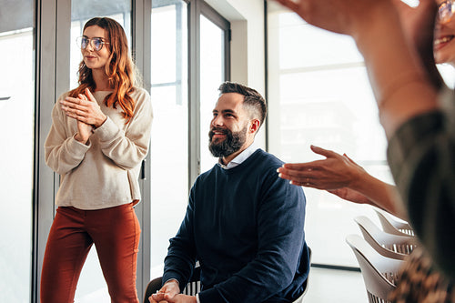 Successful businesspeople applauding in an office