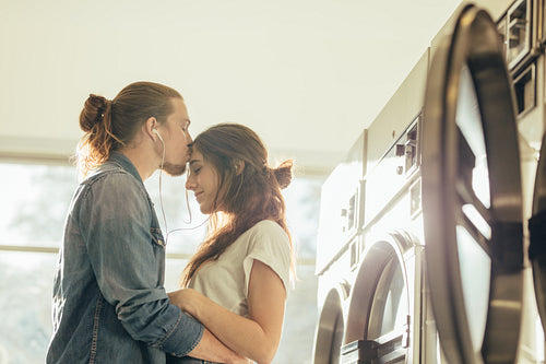 Man embracing his girlfriend and kissing on forehead