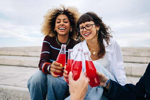 Friends cheering with red soda in candid moment