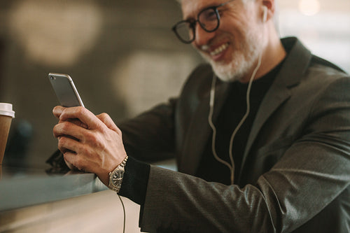 Businessman using phone at cafe