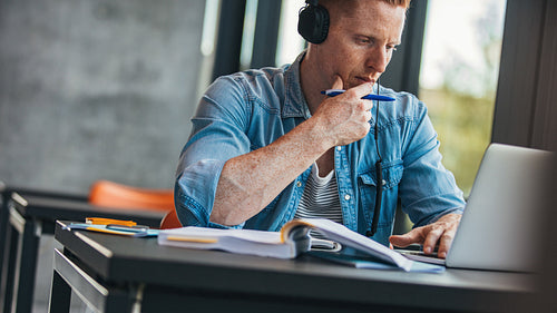 Pensive student with laptop studying in the library