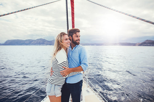 Romantic young couple standing together on a yacht