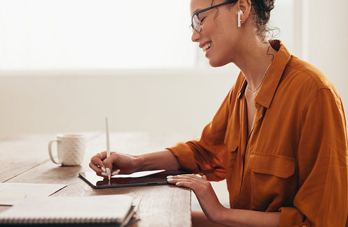 Woman using digital tablet working from home