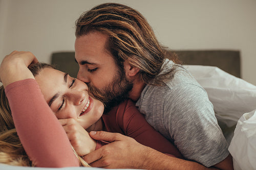 Couple lying on bed romancing