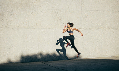Healthy woman running and jumping outdoors