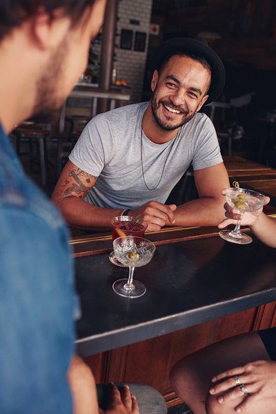 Young friends sitting at a cafe table having drinks