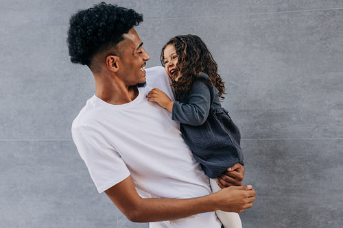 Happy father and daughter laughing and having fun in a studio