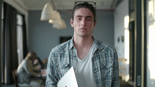Man in office with colleagues meeting in the background