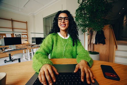 The work scene shows a woman smiling at her laptop with a phone on the desk