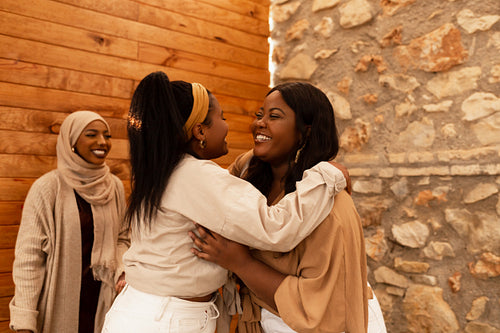 Female friends greeting each other with a hug in a cafe