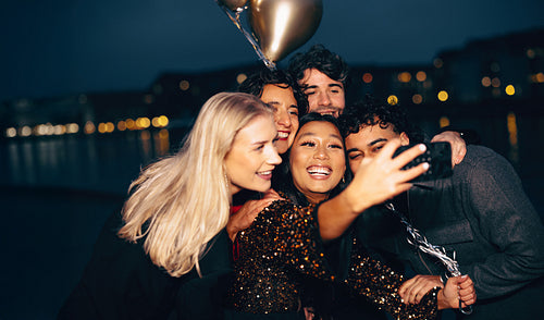 Friends enjoying an evening and capturing memories with a nighttime selfie