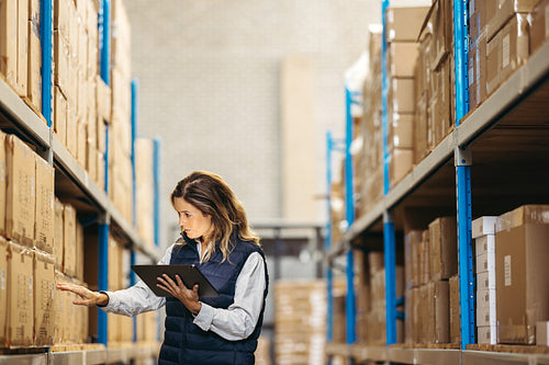 Logistics worker checking SKU's against an inventory list on a tablet